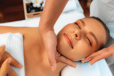 Kafkasyalı kadın stres önleyici kafa masajından ve lüks tatil beldesi ya da otel spa salonundaki modern ışık ortamında yüz güzelliği eğlencelerini şımartmaktan hoşlanıyor. Sessiz.