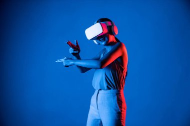 VR kulaklık takan zeki bir kadın metaevrene bağlanıyor, gelecekteki siber uzay topluluğu teknolojisi. Sanal silaha hükmeden zarif bir kadın ciddi ciddi oyun oynuyor. Halüsinasyon.