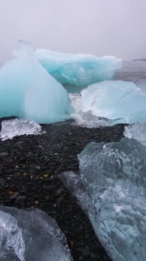 İzlanda 'daki Diamond Sahili' ndeki buzdağları. Elmas Plajı olarak bilinen kara kumsalda donmuş buz, Vatnajokull Ulusal Parkı 'ndaki Jokulsarlon Gölü' nden, Avrupa 'nın güneydoğusundaki İzlanda' dan akar..