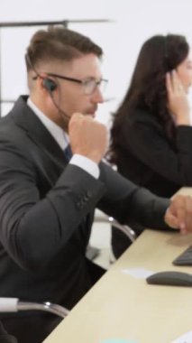 Ofiste çalışan kulaklık takan işadamları uzak müşteri ya da meslektaşlarını desteklemek için çalışıyorlar. Arama merkezi, tele pazarlama, müşteri destek acentesi telefon görüşmesinde hizmet sunar.