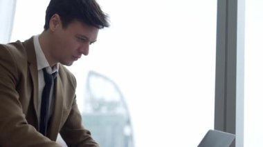 Mobilyaların üzerinde oturan işadamı hazırlanmak için süslü şirket bekleme alanında dizüstü çalışıyor. Ofis çalışanı veya iş mesleği ve ticari başarı için stratejik pazarlama planı.