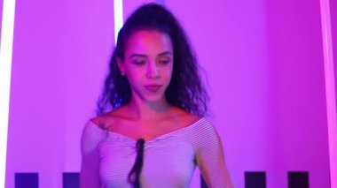 Stüdyoda mor ışıkla sokak dansı yapan İspanyol sokak dansçılarına yakın çekim. Profesyonel sanatçı şık kumaşla enerjik bir hareket sergiler. Çılgın, komik. Yarı vücut. Mutluluk.