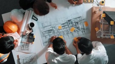 Becerikli mühendis ekibinin ev inşaatından bahsedişinin en alt görüntüsü. Mimar ya da tasarımcı grubunun planlar hakkında beyin fırtınası yapmak için tartışan ve yazan hava görüşü. Hizalama.
