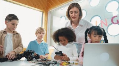 Öğretmen öğrencilere dijital elektrikli aletleri ya da araba modelini öğretir ve açıklar. Çeşitli çocuklar elektronik aletleri öğrenip ana kartı ya da kablolu robot modelini tamir etmeyi öğrenirler. Etkinlik.