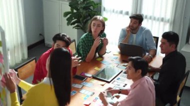 Yetenekli proje yöneticisinin üst düzey görüşü, pazarlama fikrini beyaz tahtada durup yatırımcıya bakarken açıklıyor. Planı tartışırken sunum dinleyen çeşitli iş adamları. Cemaat.