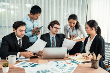 Ofis masasındaki finansal veri raporlarını analiz eden çeşitli bir grup iş analisti. Stratejik pazarlama planlaması için iş istihbarat analizine göre grafikler ve grafikler.
