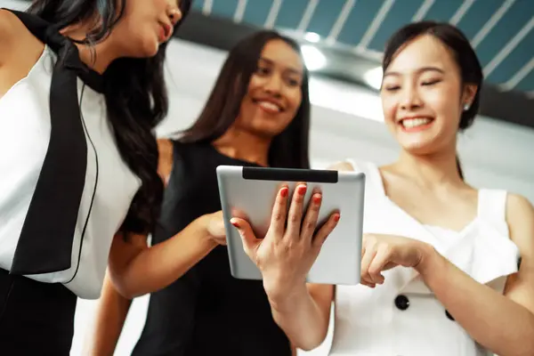 stock image Three Asian women friends having conversation while looking at tablet computer in their hands. Concept of social media, gossip news and online shopping. uds