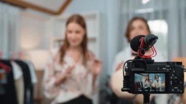 İki kadın nüfuzlu kişi canlı yayın yapan video klip eleştirisi kıyafetlerini sosyal medyada ya da blogda yayınlıyor. Stüdyo ışıklandırmalı mutlu genç kız çevrimiçi pazarlama oturumu yayını için..