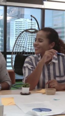 Yaratıcı iş adamları modern işyerindeki ofis masasında sohbet ediyorlar. Şirket uluslararası iş kavramı.