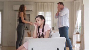 Sinirli ve mutsuz genç bir kız oturma odasında ebeveyninin tartışması yüzünden gerginliğin ortasında kanepede oturuyor. Sağlıksız ev hayatı ve travmatik çocukluk depresyona dönüşür.