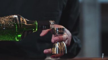 Karışık kokteyl barı hazırlamak için likör şekerini ölçmek için jigger tutan el barmenini yakından karıştırıyorum. Gece hayatı karışımı davetler veren özel bir içecek. Vinosity.