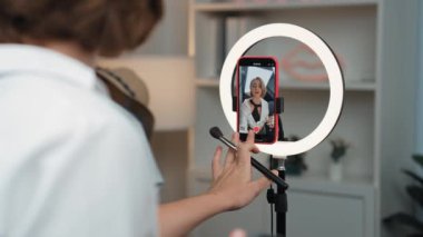 Arka plan etkileyicisi, vlog video gözden geçirme makyaj primi sosyal medya ya da blog kullanarak akıllı telefon yayınıyla canlı çekim yapıyor. İnternetteki pazarlama kaydı için kozmetik stüdyosu ışıklandırması olan kız.