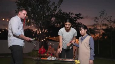 Aile birlikte bahçede kamp kurar, anne baba ve kız aile bireyleri için ızgara yapar. Doğayla iç içe olmak için açık hava kamp aktiviteleri ve genç nesil çapraz kuşaklarla zaman geçirmek için. Uyumsuzluk.