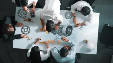 Mühendis ekibinin toplantıda metal teçhizat, hesap makinesi ve ekipmanlarla toplantı masasında türbin motoru veya elektrik jeneratörü hakkında tartışırken yapışkan notlar üzerine yazı yazma fikrinin en üst görüntüsü. Hizalama.