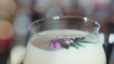 Kapalı tutku meyveleri ve üzerine pembe çiçek eklenerek süslenmiş tatlı likör kokteyli, alkol serinletici vitrin odaklı reklamı için özel yaratıcı içecek menüsü listesi oluşturuyor. Vinosity.