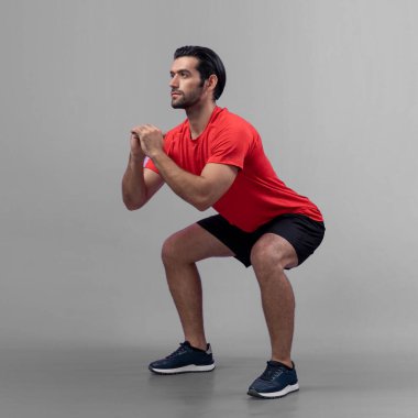 Vücut uzunluğunun tamamı atletik ve sportif genç bir adam tarafından izole edilmiş arka planda egzersiz pozisyonunda çekilmiştir. Sağlıklı aktif ve vücut bakımı yaşam tarzı.