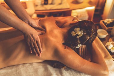 Beyaz kadın müşteri stres önleyici spa masajının keyfini çıkarıyor ve lüks otel ya da otelde sıcak mum ışığında güzellik teniyle eğleniyor. Sessiz.