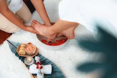 Adam lüks kaplıcalarda mutlu ayak masajına devam ederken, masör de hafif gün ışığı atmosferinde refleksoloji terapisi ya da otel ayak spa 'sında. Sessiz.