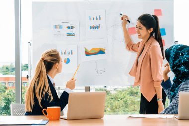 Çok kültürlü çalışma grubu. Farklı etnik kökenden iş kadınları, Kafkasyalı, Asyalı ve Araplardan oluşan bir ekip ofiste dizüstü bilgisayarla birlikte çalışıyor. Çok ırklı takım çalışması konsepti. uds