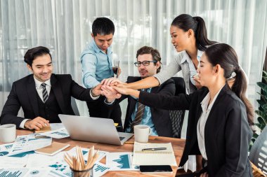 Kutlama jesti ve başarılı takım çalışması yapan bir grup mutlu iş adamı. Çeşitli yarış bürosu çalışanları şirket ofisinde pazarlama planlamasında ilerleme kaydettikten sonra kutlama yapıyorlar. Çok titiz.