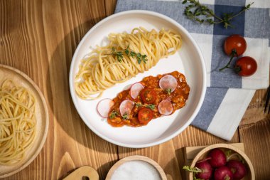 Lezzetli yiyecekler, ev yapımı spagetti, kıymalı domates sosu ve fesleğen fırlatma elementleri, şef masası dekoratif baharatlarla servis ediliyor. Varsayım.