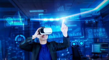 VR gözlüklü bir proje yöneticisi mali tabloyu ve ofisteki parlak mavi ışığı gösteriyor. Yetenekli iş adamı artırılmış gerçeklikten elde edilen verileri kullanarak pazarlama stratejisini kontrol edip planlıyor. Yaratıcılık.
