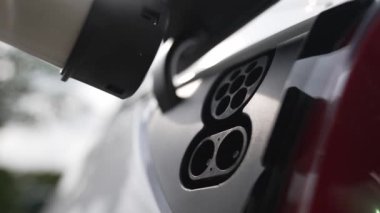 EV şarj prizi kapağı elektrikli arabaya bağlanıyor, EV araba aküsünü temiz çevre için sıfır CO2 emisyonu ile alternatif ve sürdürülebilir enerjiyle şarj ediyor. Titiz