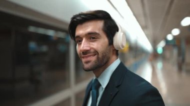 Akıllı bir iş adamı tren istasyonunda kulaklık takarken telefon eder. Profesyonel yönetici, tren ya da metro beklerken pazarlama stratejisi hakkında meslektaşıyla konuşuyor. Sevinçli..