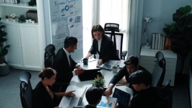 Toplantı odasındaki tabletten finansal istatistiklere bakan akıllı yöneticinin en üst görüntüsü. Masadaki yatırım verilerini not defteriyle analiz etmek için birlikte çalışan bir grup iş adamı. Müdürlük.