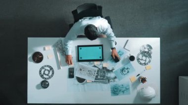 Türbin motoru veya jet motoru tasarımı ve çeşitli metal teçhizat dağılımı ile toplantı masasında yeşil ekranlı tablet üzerinde çalışırken telefona bakan mühendis görüntüsü. Hizalama.