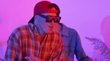 Break dansçı takımının modern stüdyoda pembe ışıkla dans etmesini kapatın. Çok kültürlü insanlar moda kıyafetleri giyerek hip hop müziğine geçiyorlar. Çılgın, komik bir ruh hali. Mutluluk.