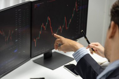 Modern ofisteki mali risk veri tabanına gerçek zamanlı döviz kuru yatırımı yapan iki tüccarın dinamik borsasını tartışarak bilgisayar ekranlarına odaklanıyorum. Varsayım.