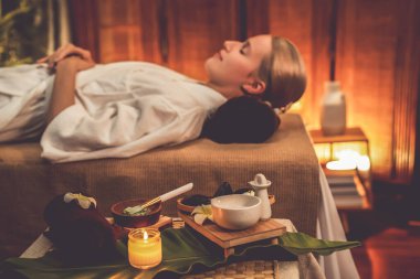 Aromaterapi masajı ambiyansı ya da spa salonu kompozisyon düzeneği bulanık kadınlara odaklı dekor mumları ve spa aksesuarları ile tatil köyü veya otel arka planında keyifli aroma spa masajı yapan. Sessiz.