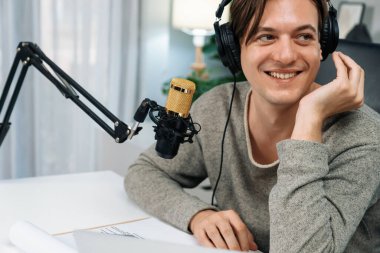 Sunucu kanalı, gülümseyen akıllı yayıncı kaydı, senaryosu ve akıllı telefonuyla sosyal medyada sohbet programı, kulaklık takarak modern ev stüdyosundaki video flamalarını kaydediyor. Bireysel.