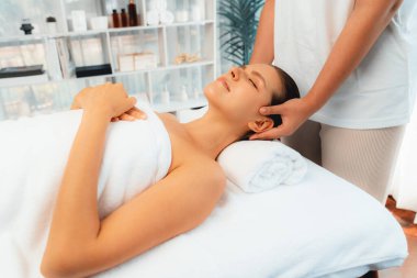 Kafkasyalı kadın stres önleyici kafa masajından ve lüks tatil beldesi ya da otel spa salonundaki modern ışık ortamında yüz güzelliği eğlencelerini şımartmaktan hoşlanıyor. Sessiz.
