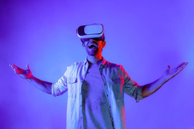 VR gözlük takan gülümseyen adam sanal gerçeklik dünyasına giriyor. Beyaz ergen, ekipman kullanarak siber uzay gelecekteki yenilikçi teknoloji simülasyonuna bakarken heyecanlanıyor. Sapma.