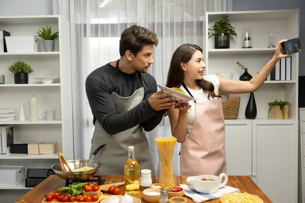 stock image Making photo selfie in couple chef influencers completely cooked spaghetti with meat topped with tomato sauce special dish recording on camera, serving healthy food at modern home chanel. Postulate.