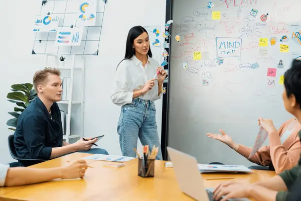 Stock image Young beautiful leader presents marketing strategy while expert investor and project manager lecturing to analyze business performance at start up business meeting. Multiethnic group. Immaculate.