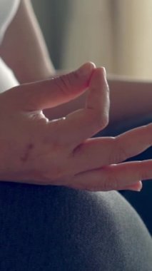 Hamile bir kadın, çocuğuna bakarken yatak odasında yoga egzersizi yapıyor. Hamile karnında bebek tutan mutlu, genç bir anne. Doğum öncesi bakım ve hamilelik.