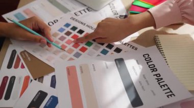 Grafik tasarımı için renk seçimi yapan ve beyin fırtınası yapan iki tasarımcının yavaş çekim çekimi ya da tasarım bürosunda kromatik danışmanlık hizmeti isteyen bir müşteri. Değiştirilmiş