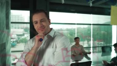 Akıllı lider işadamı cam tahtanın önünde proje başlatmayı düşünüyor. Gülümseyen erkek proje yöneticisi yaratıcılık pazarlama stratejisini gösteren renkli yapışkan notlara bakıyor. Yönlendirici.