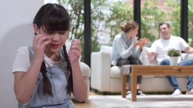 Stresli ve mutsuz genç kız köşeye kıvrılıp kulaklarını kapatarak arka planda ebeveyninin tartışmasını engelliyor. Evde aile içi şiddet ve travmatik çocukluk depresyona dönüşür. Titiz