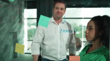 Yetenekli işadamı pazarlama fikrini cam duvardaki proje yöneticisine sundu. Yönetici projeyi yatırımcıya açıklıyor. Zeki iş adamları birlikte çalışıyor, beyin fırtınası yapıyorlar. Yönlendirici.