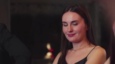 Lüks bir kokteyl barında grup arkadaşıyla konuşan güzel bir kadının portresi. Gece kulübünde sosyetik etkileşim için doğal yüz güzelliğini kostüm içinde yakalamak. Vinosity.