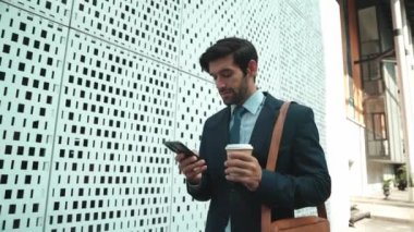 Akıllı iş adamı iş yatırımları hakkında konuşmak için telefonu kullanıyor. İş planı, pazarlama stratejisi ya da çalışma hakkında konuşmak için akıllı telefonla konuşurken sokakta yürüyen mutlu bir yönetici. Sevinçli..