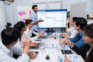 Proje yöneticisi monitörde proje yönetimi yazılım görüntülemesi, proje görevinin ilerlemesini izlemek ve toplantı masasında program planı yapmak suretiyle ekiple iletişim kurar ve işbirliği yapar. Tedbirli