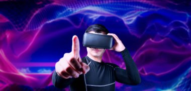 Cüppeli ve soyut arka planda duran Asyalı zeki bir adam. Uzman oyuncu metaevrene giriş yaparken arttırılmış gerçeklik kulaklığı takıyor ve video oyunu oynuyor. Yaratıcılık.