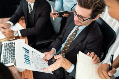 Ofis masasındaki finansal veri raporlarını analiz eden çeşitli bir grup iş analisti. Stratejik pazarlama planlaması için iş istihbarat analizine göre grafikler ve grafikler.