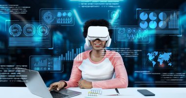 Masada kitap ve dizüstü bilgisayarla ödev yaparken metaevreleri birbirine bağlayan dizüstü bilgisayar ve artırılmış gözlük kullanan bir kız. Öğrenci holograma bakıyor ve yapay zekayı kullanıyor. Yaratıcılık.