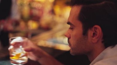 Yakın plan akıllı adam, Cuma gecesi Bokeh Lights 'ın gece kulübündeki içki tezgahında içki hazırlarken eski moda arkadaşlarıyla ya da çiftlerle kokteyl içiyor. Vinosity.